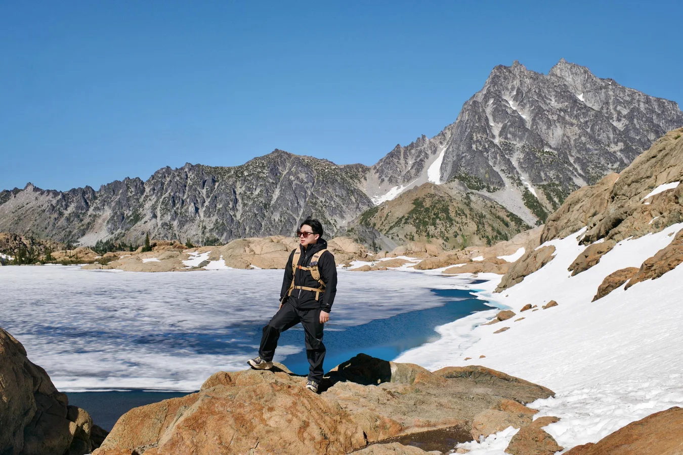 Standing above a frozen alpine tarn